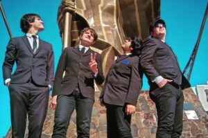 Banda Argentina, Star Beatles, tributo internacional aos Beatles. A imagem mostra a formação da banda, com quatro homens de terno preto em contraste com céu azul.